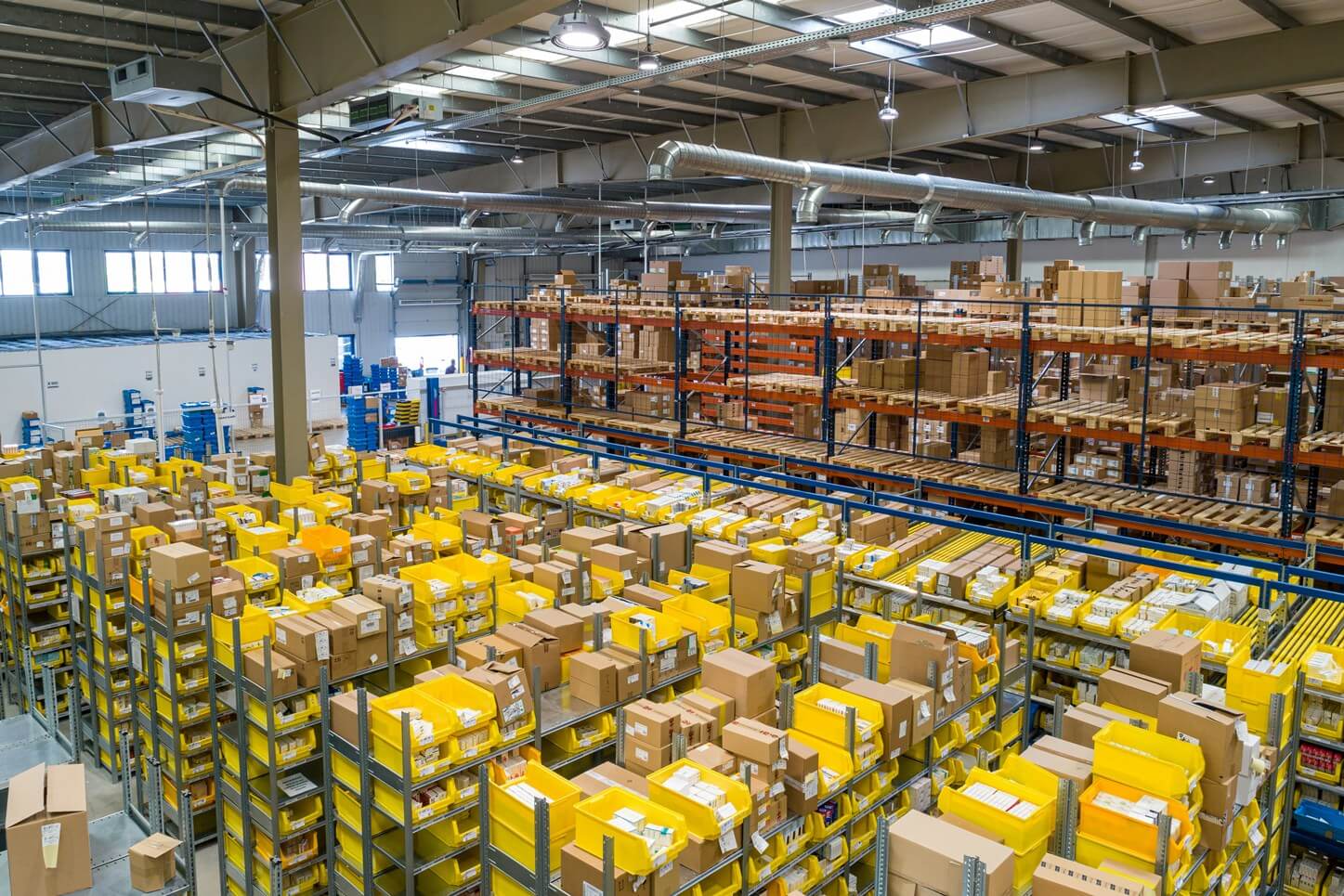 Busy e-commerce fulfilment centre with conveyors, parcels and packing operations